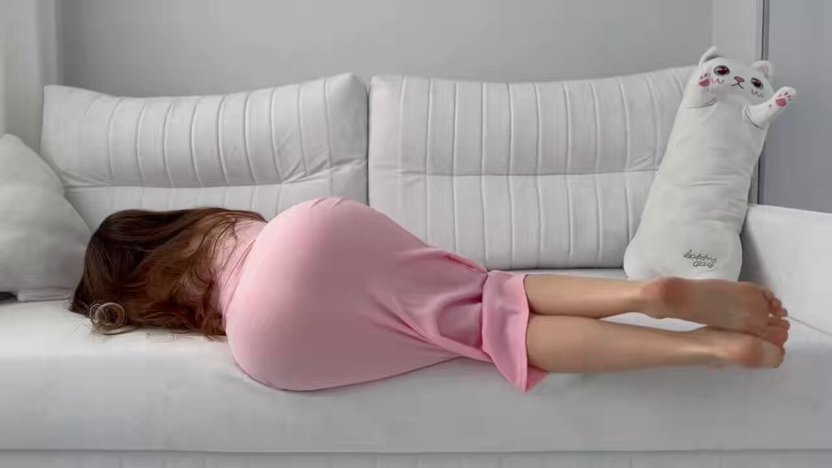 ピンクワンピの美女が横たわり誘惑、プリッとしたヒップと猫のおもちゃそばで露出する美脚