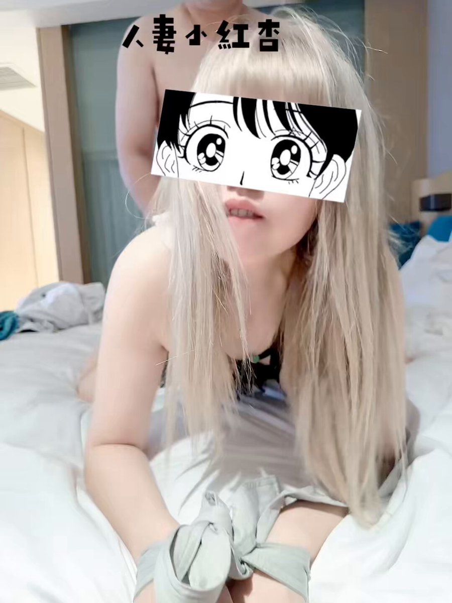 Blonde adult cosplayer wearing an anime eyepatch, writhing in bed and seductively moaning