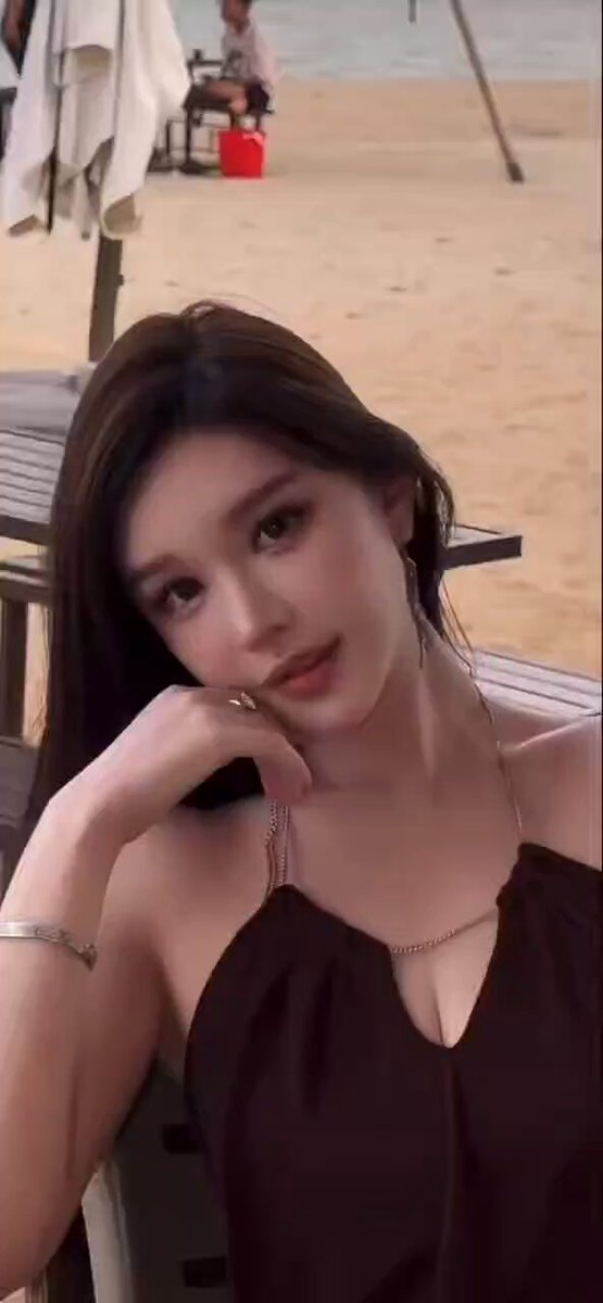 深Vで胸を覗かせるビーチの色っぽい美女