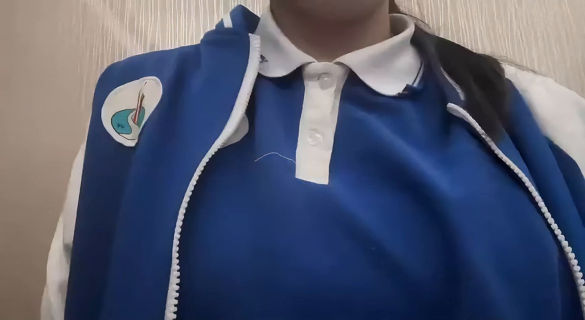 Busty woman in blue-and-white sports jacket unzips and fondles her breasts, exposing erect nipples