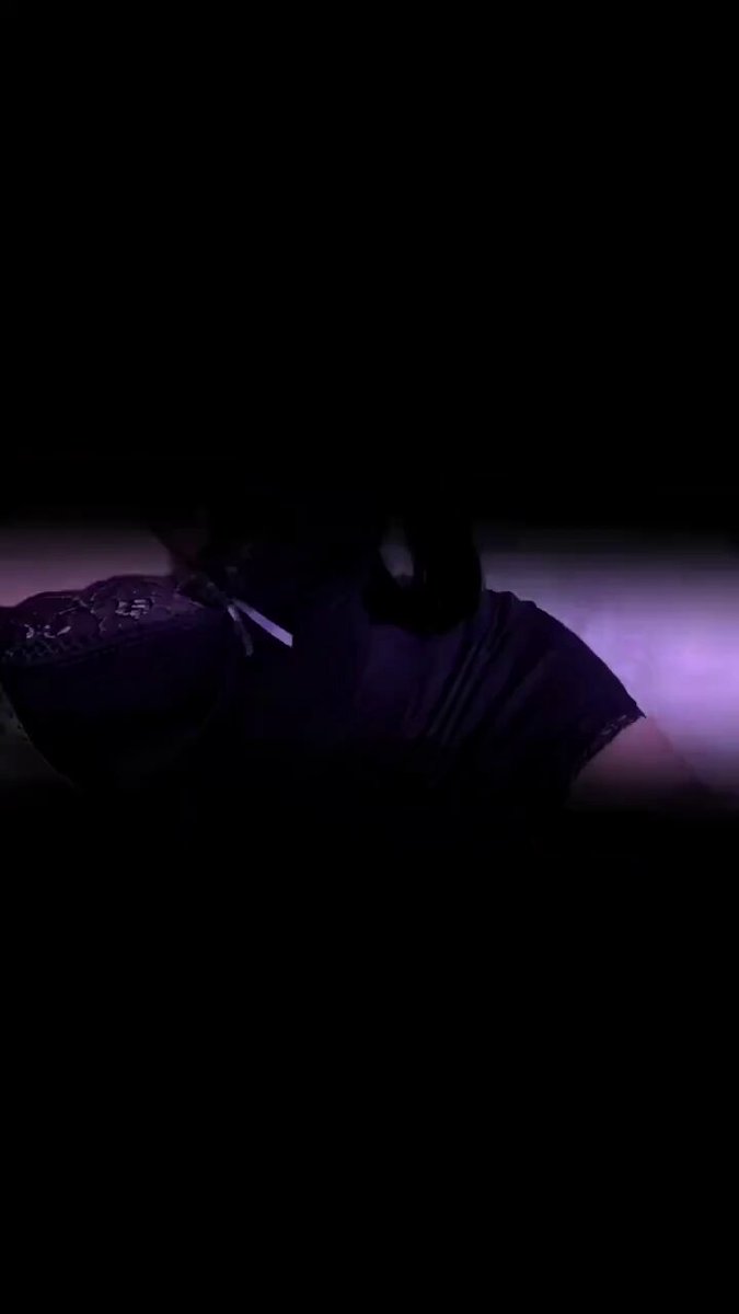 黒スト美女、紫の光の誘惑—ソファで横たわり脚を開いてヒップを見せる