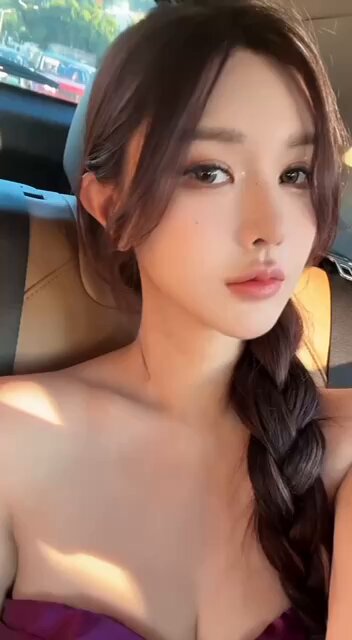 Busty beauty teases with car selfie! Purple low‑cut top shows large breasts and side cleavage swaying