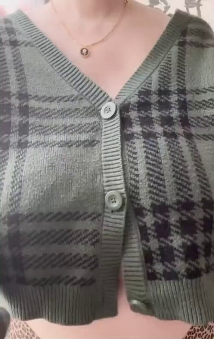 Busty beauty in a plaid sweater slowly unbuttons, teasing with exposed breasts