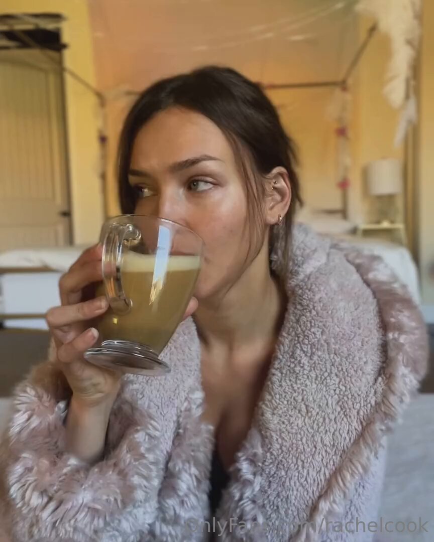 美女がバスローブを脱ぎ、巨乳を露出しながらジュースを飲む — 上半身裸で誘惑し、座って乳首を弄る