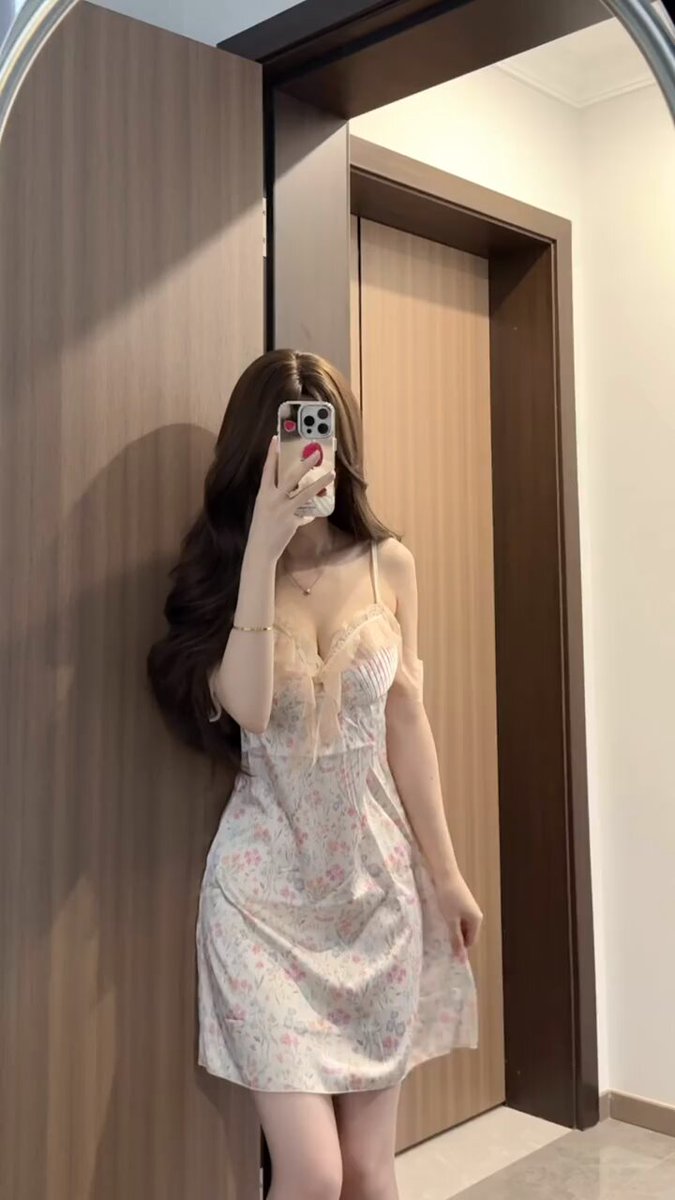 長い髪の美女が鏡の前でセクシーなナイトドレスを自撮り、豊かな胸の深めVがちらりと見える