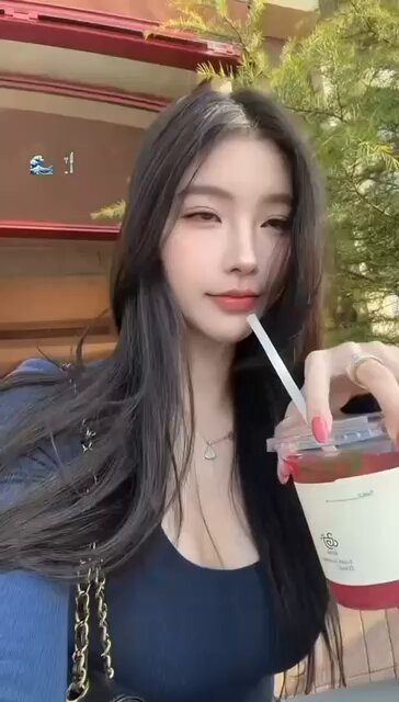 Long-haired Beauty Teases with a Straw on the Street — Busty Deep-V Temptation
