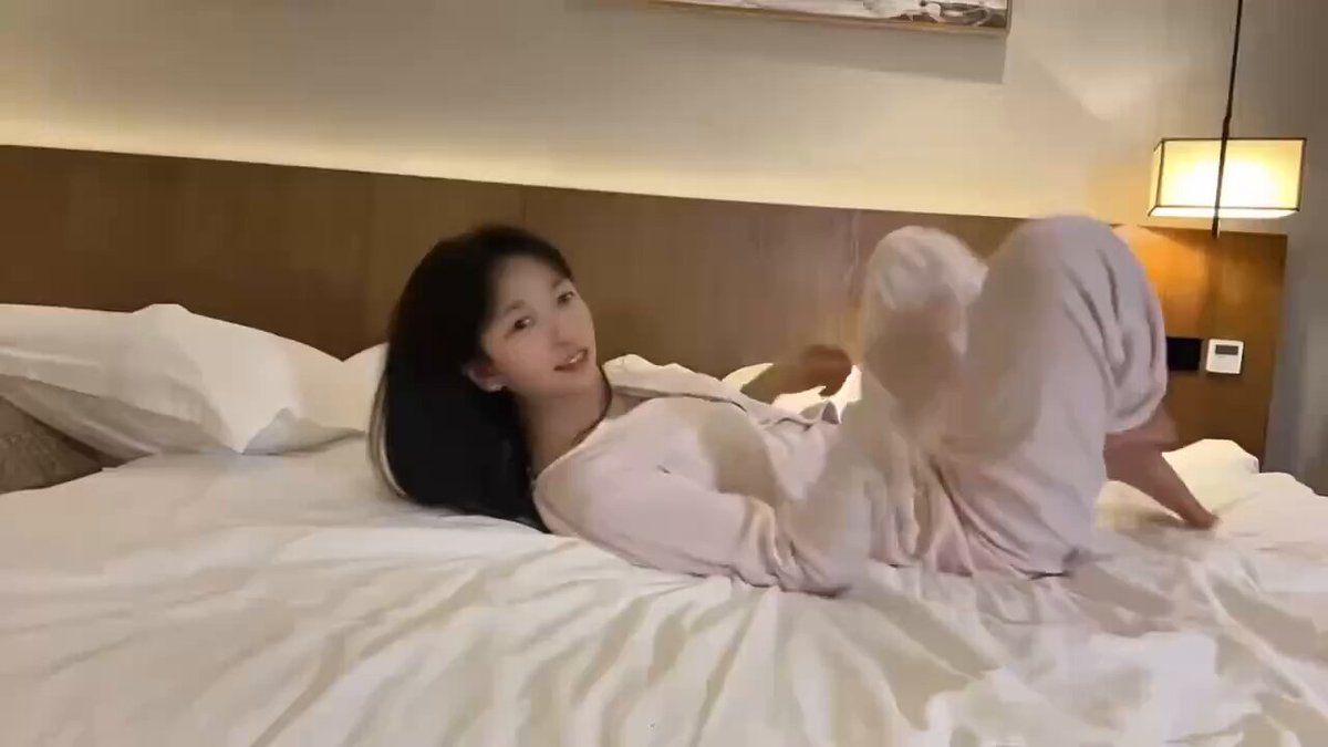 Hotel Bed Young Beauty in Pink Pajamas Raises Her Legs and Teases