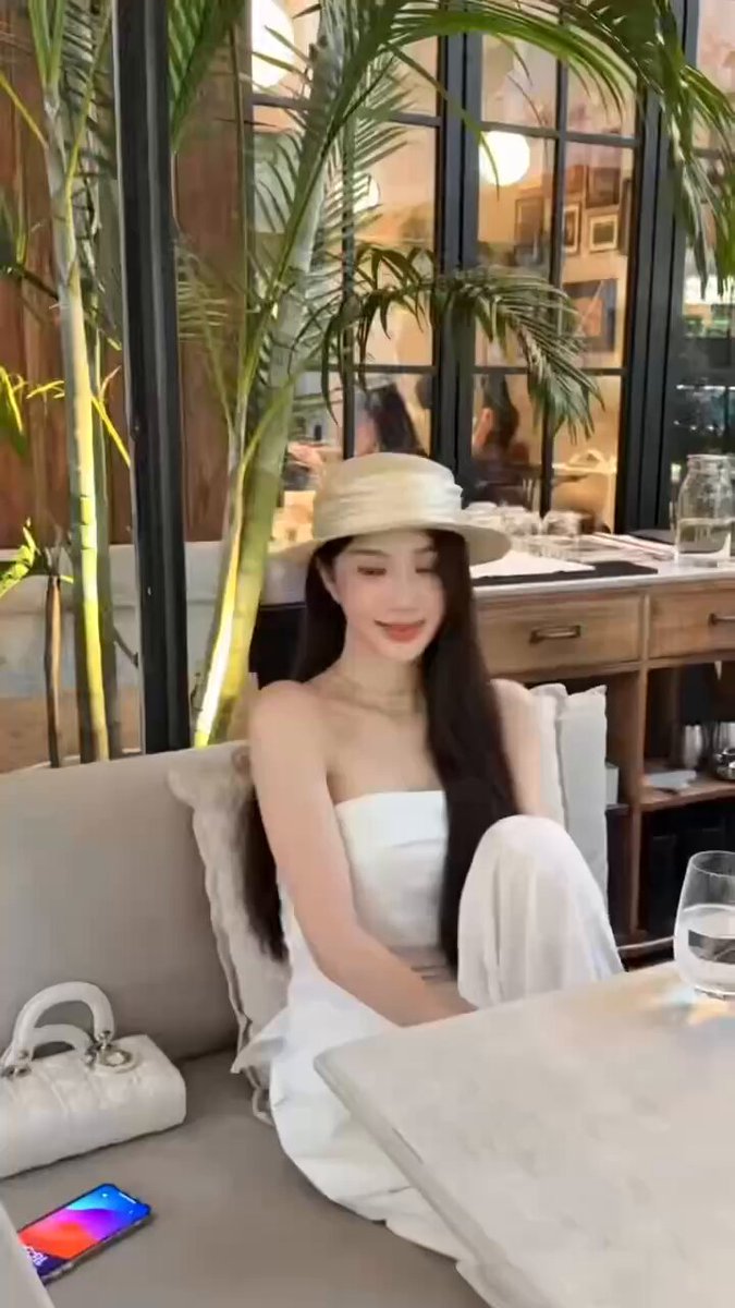 Straw-Hat Beauty in an Off-Shoulder White Dress, Seductive Sitting Pose, Gorgeous Long-Haired Girl's Flirtatious Smile