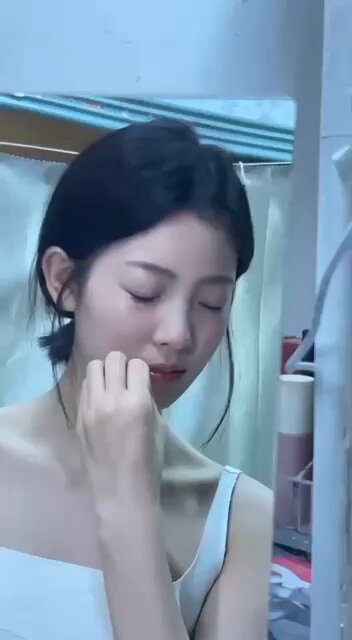 In the bathroom, a black-haired beauty with a wet body seductively touches her face, extremely arousing