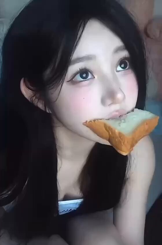 Long Black Straight-Haired Beauty Bites Bread, Exposes Breast and Seductively Swallows
