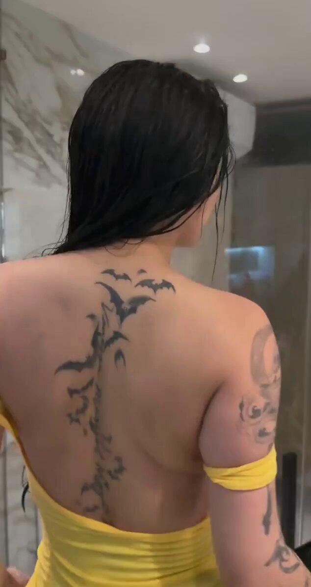 Bathroom hottie in a yellow dress shakes her perky butt, showing off bat tattoo temptation