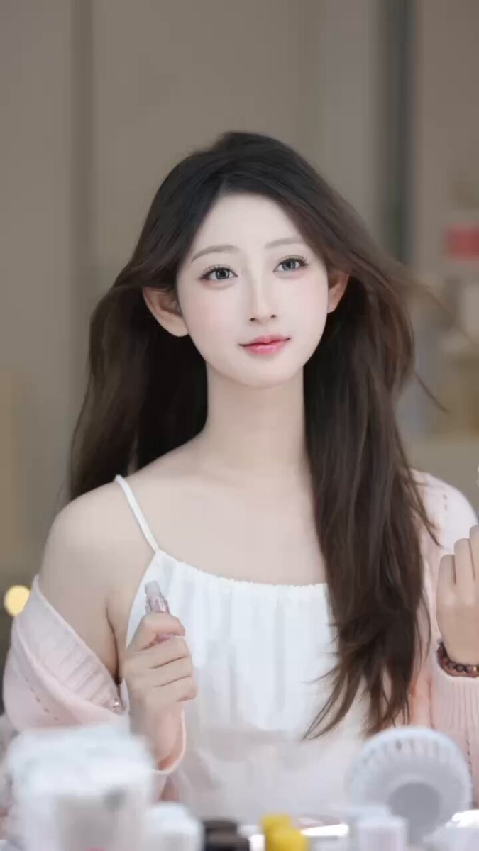 Innocent-Looking Vixen: Long-Haired Beauty Teases While Applying Makeup, Strappy Top Partially Revealing Her Breasts