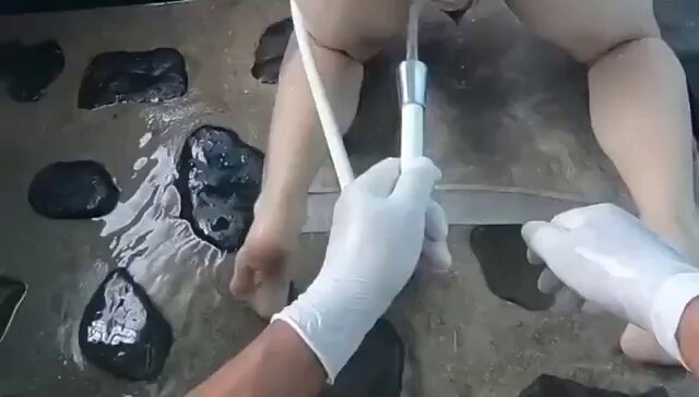 Bruk en analdilator for å åpne tispenes anus helt, og vask den deretter gjentatte ganger med vannslange og et klyster. 🎬 